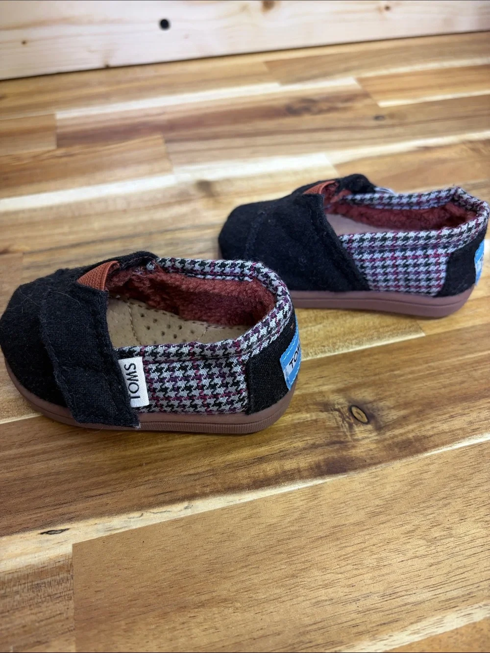 Toms Black Baby Slip-Ons with Rust Accent and Patterned Trim
